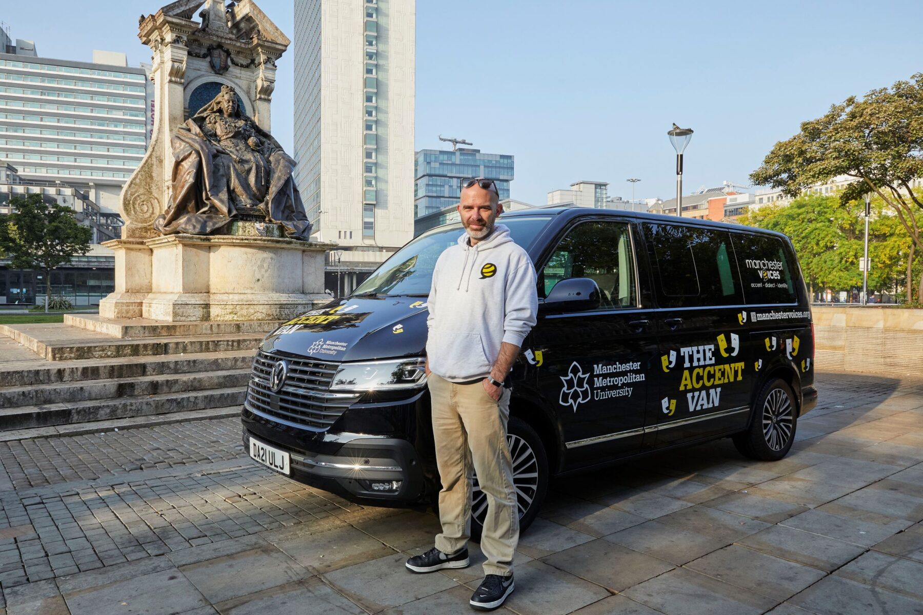 dr rob drummond from the manchester voices project standing in front of the accent van in piccadilly manchester